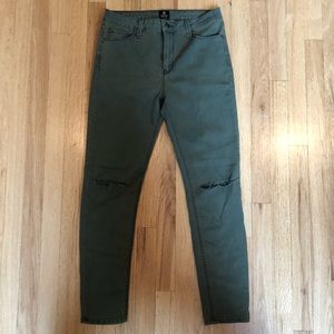 Dark green jeans with one rip in the knee